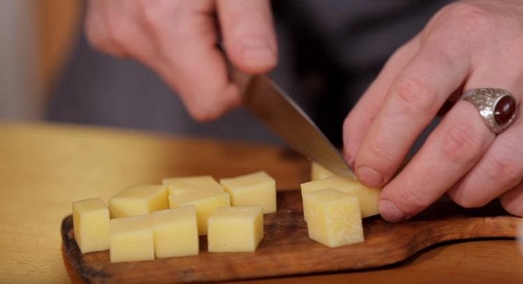 Taglia a dadini il formaggio a pasta dura.