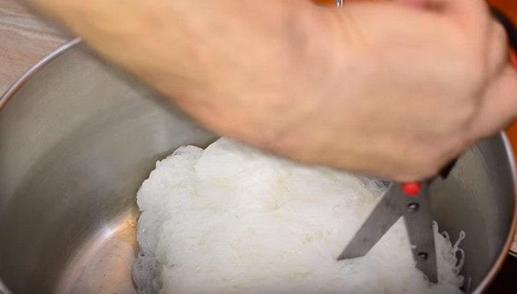 Dopo aver lavato gli spaghetti di riso finiti, tagliarli con le forbici.