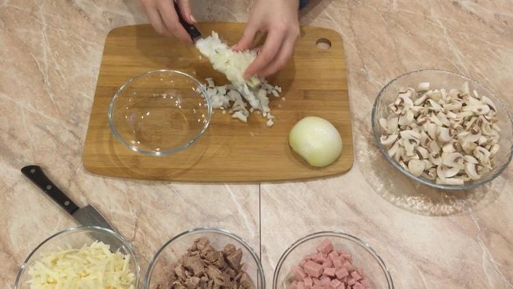 Per preparare la julienne in tortine, tritare la cipolla