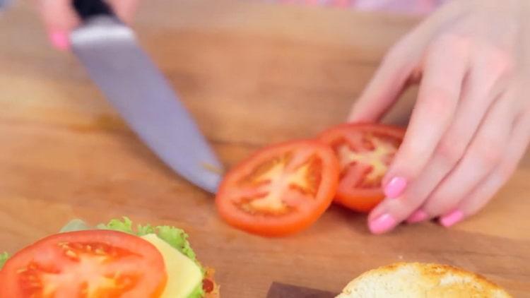 Per cucinare un crabsburger, tagliare il pomodoro