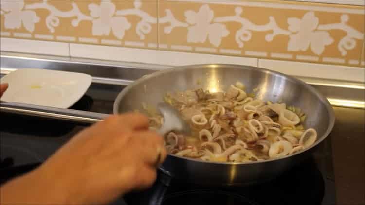 Friggere gli ingredienti per il riso di seppia.