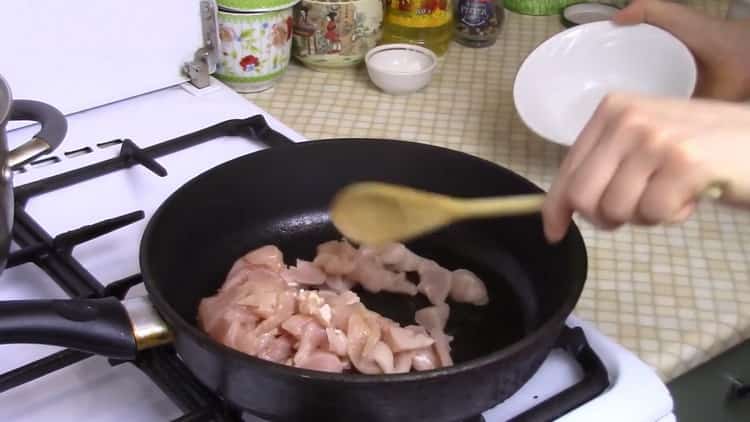 Friggere la carne per preparare gli spaghetti di riso