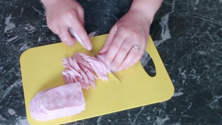 Per cucinare i fagioli, tagliare il prosciutto