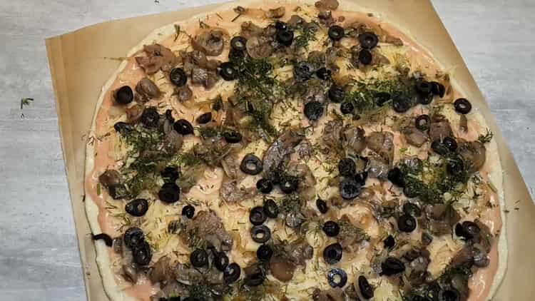 Per fare la pizza, metti il ​​ripieno sull'impasto