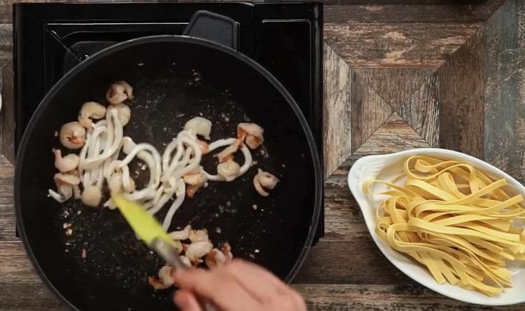 Friggere i frutti di mare per preparare le fettuccine