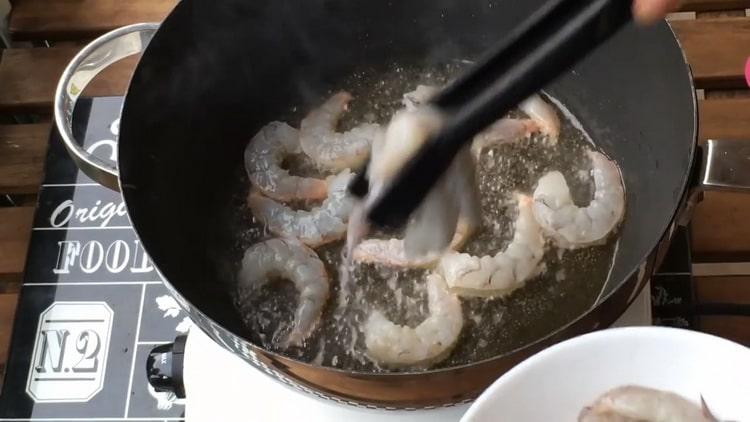 Friggere i gamberi per preparare le fettuccine