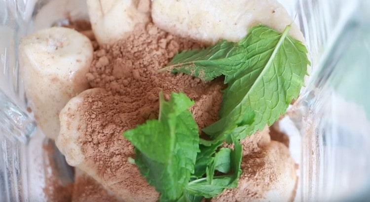 Metti le banane congelate, il cacao, le foglie di menta, il latte condensato in una ciotola del frullatore.