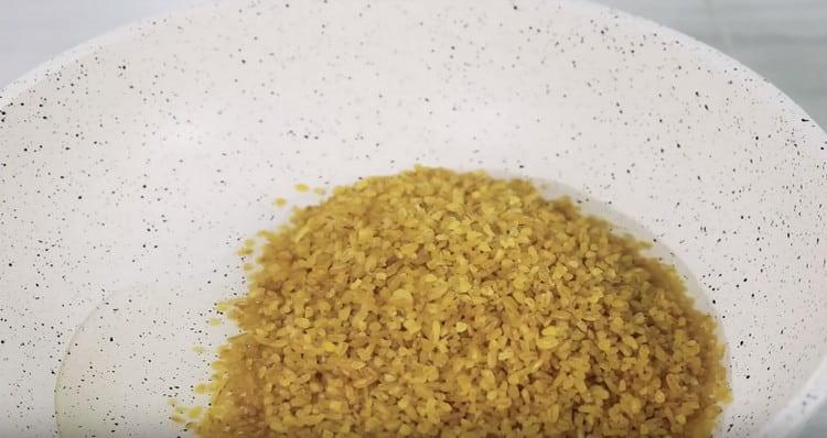 Riscaldiamo l'olio vegetale in una padella e distribuiamo il bulgur.