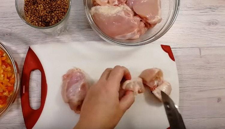 La carne di pollo viene tagliata a pezzi.