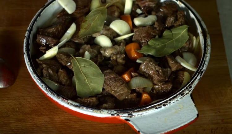 Aggiungi carne fritta alle verdure, aggiungi aglio, alloro, spezie.