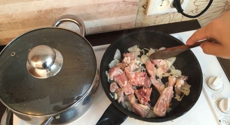 Friggere il pollo con le cipolle in una padella.