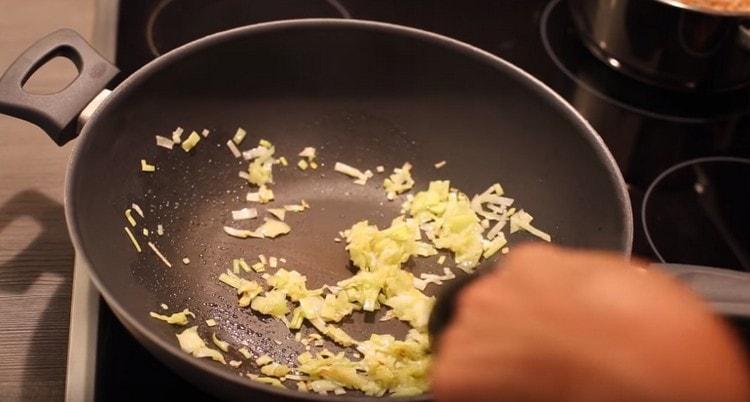 Friggere le cipolle in una padella.