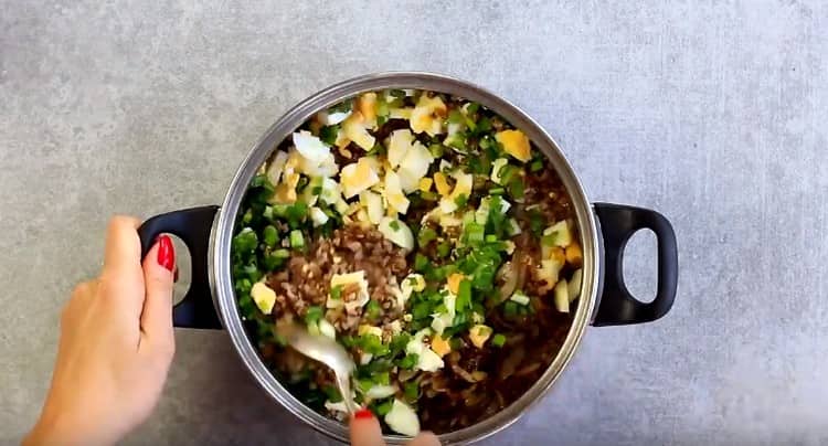 Mescolare il grano saraceno con uova, cipolle e cipolle verdi.