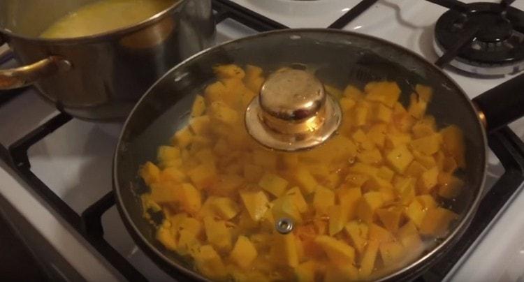 Distribuiamo le fette di zucca in una padella, aggiungiamo acqua e cuociamo a fuoco lento sotto il coperchio.