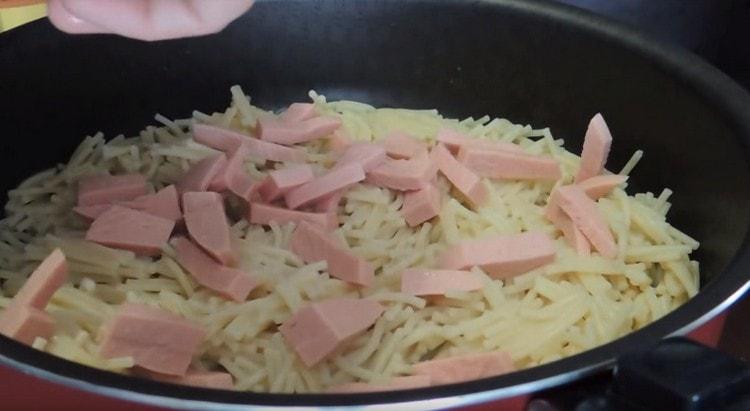 Sulla parte superiore della pasta stendere pezzi di salsiccia.