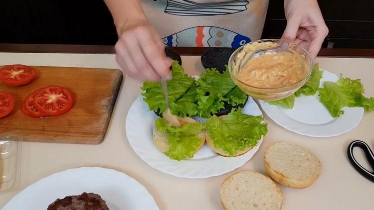 Per preparare hamburger, ungere un panino con salsa