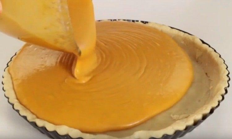 Rimuoviamo i pesi e versiamo il ripieno di zucca sulla base per la torta.