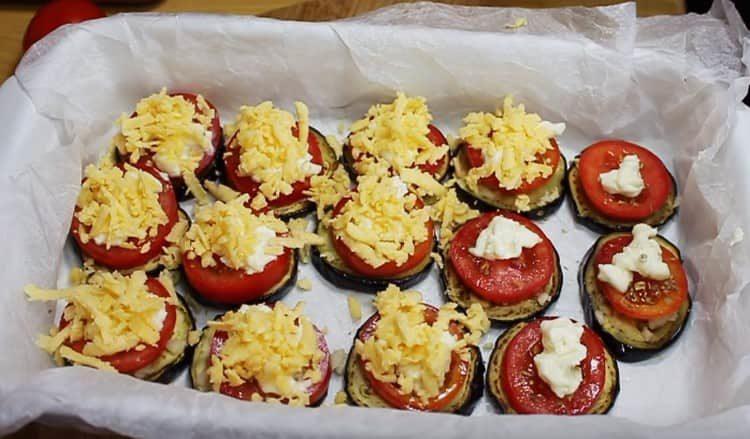 Sopra i pomodori, spalmare il formaggio cremoso, cospargerlo con formaggio grattugiato.