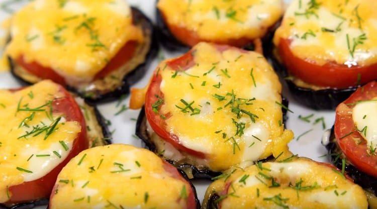 Le melanzane pronte con pomodori e formaggio possono essere cosparse di aneto tritato.