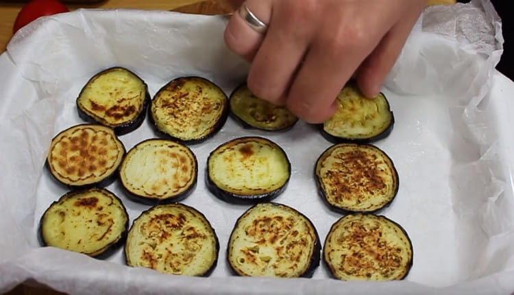 Metti le melanzane fritte in una teglia.