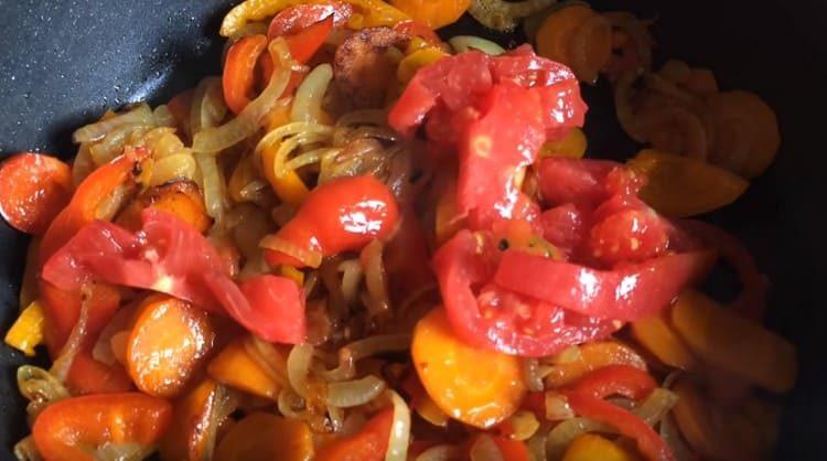 Sbucciare i pomodori dalla buccia e spargerli nella padella per le verdure.