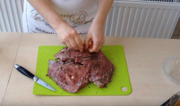 Riempiamo la carne con pezzi di aglio.