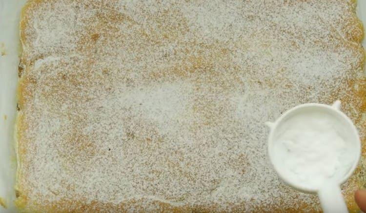 La torta gelatina pronta con le mele può essere cosparsa di zucchero a velo.