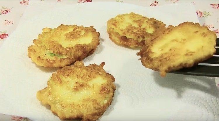 Le zucchine pronte nella pastella di formaggio vengono trasferite prima sui tovaglioli.