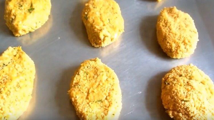 Formiamo le cotolette, le arrotoliamo nel pangrattato e le distribuiamo su una teglia.