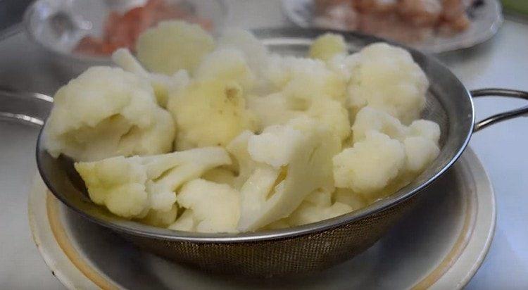 Getta il cavolo bollito in uno scolapasta.