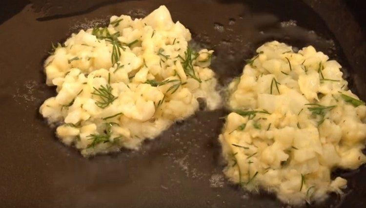 Distribuiamo la massa di cavolo in una padella riscaldata con olio vegetale con un cucchiaio.