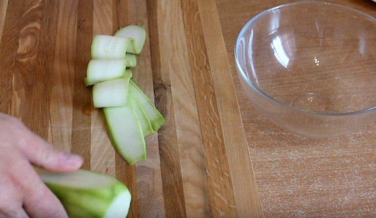 Tagliare a fettine sottili di zucchine.