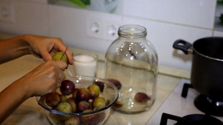 Lavare le prugne, rimuovere i semi e metterli in un barattolo.