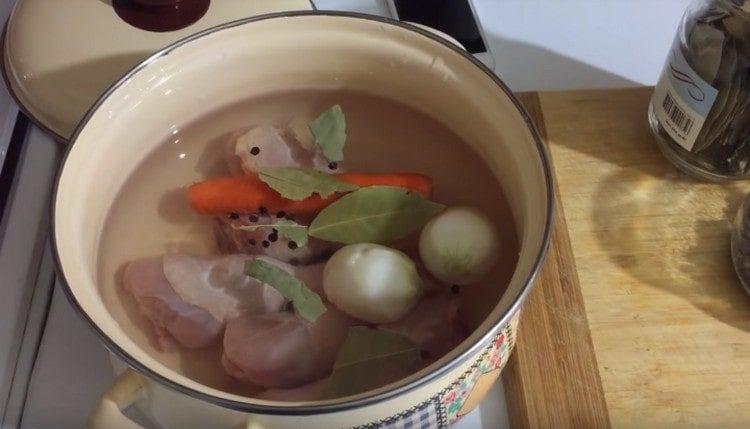 Distribuiamo cosce di pollo, verdure, peperoni, foglie di alloro in padella.