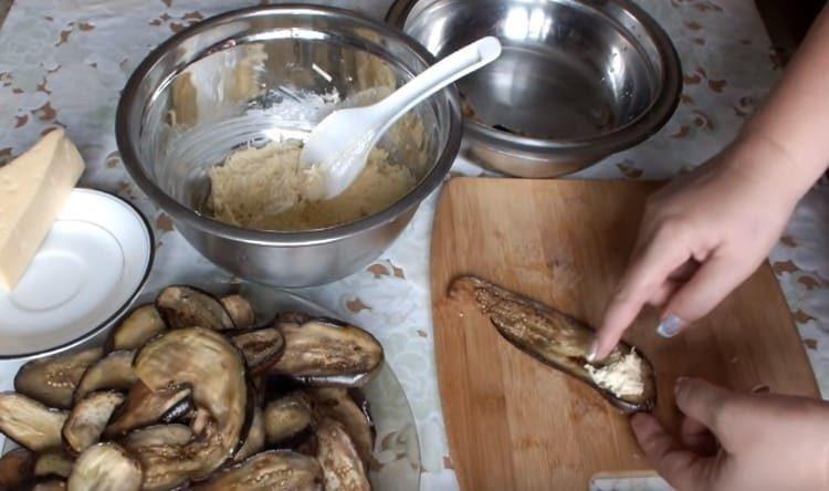 mettere il ripieno di formaggio su ogni pezzo di melanzana, arrotolarlo con un rotolo.