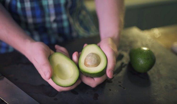 Tagliare l'avocado a metà e rimuovere la pietra.