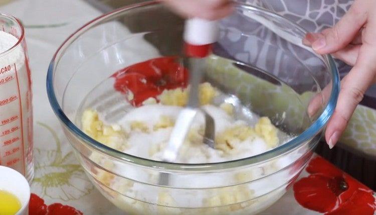 Aggiungi zucchero, sale, zucchero vanigliato alla massa di banana e mescola.