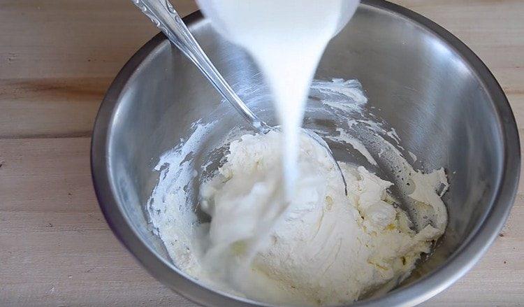 Aggiungi latte caldo alla massa della cagliata.