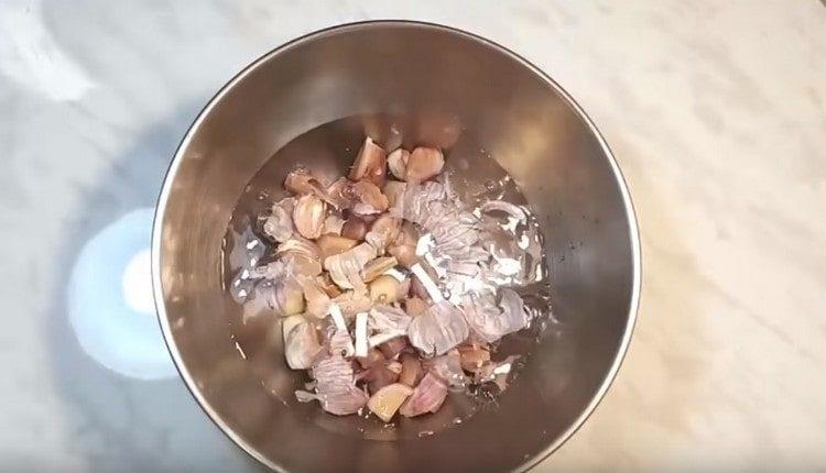 dividiamo la testa in chiodi di garofano, la mettiamo in una ciotola e la riempiamo d'acqua.