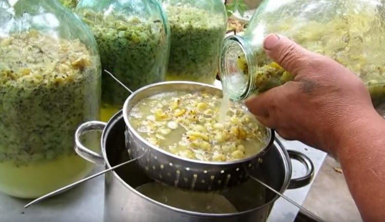 Usando uno scolapasta, filtra il vino dalla torta.