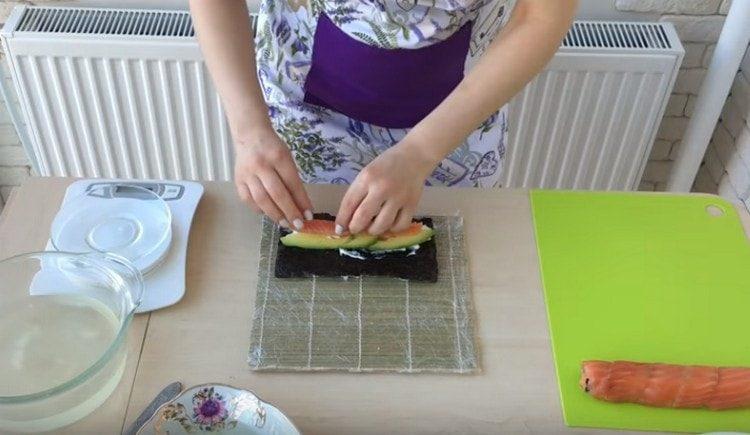 Distribuiamo formaggio, pesce e cetrioli su nori.