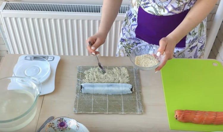 cospargere la parte del tappetino con semi di sesamo e arrotolarvi il rotolo.