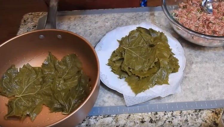 Copri il fondo della padella per cucinare il dolma con foglie di vite.