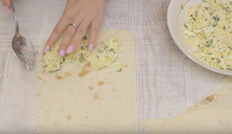 Metti il ​​ripieno su metà di ogni quadrato di pane pita