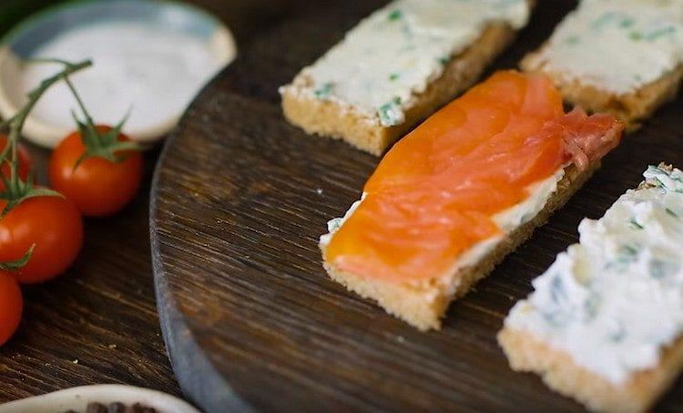 Distribuiamo fette di salmone sopra la massa di formaggio.