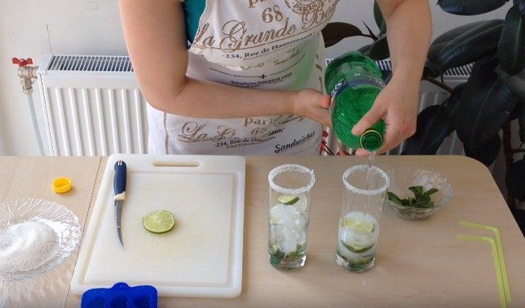 versare acqua minerale o sprite nei bicchieri.