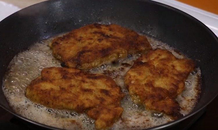 Friggere le braciole di maiale in una padella su entrambi i lati.