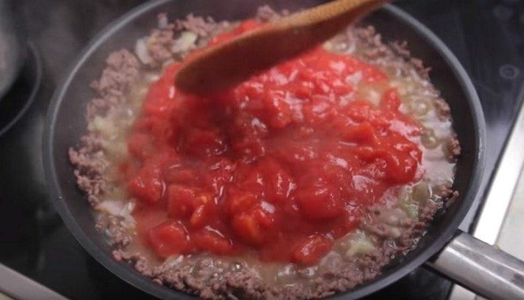 Spostiamo le verdure sulla carne macinata, aggiungiamo i pomodori nel nostro succo.