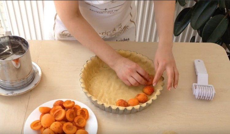 mettere le albicocche sull'impasto con la fetta verso il basso.