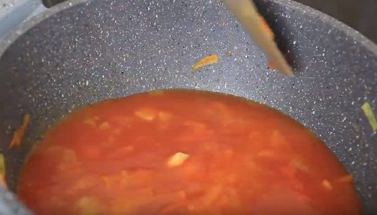 Aggiungi il succo di pomodoro a metà della massa vegetale.